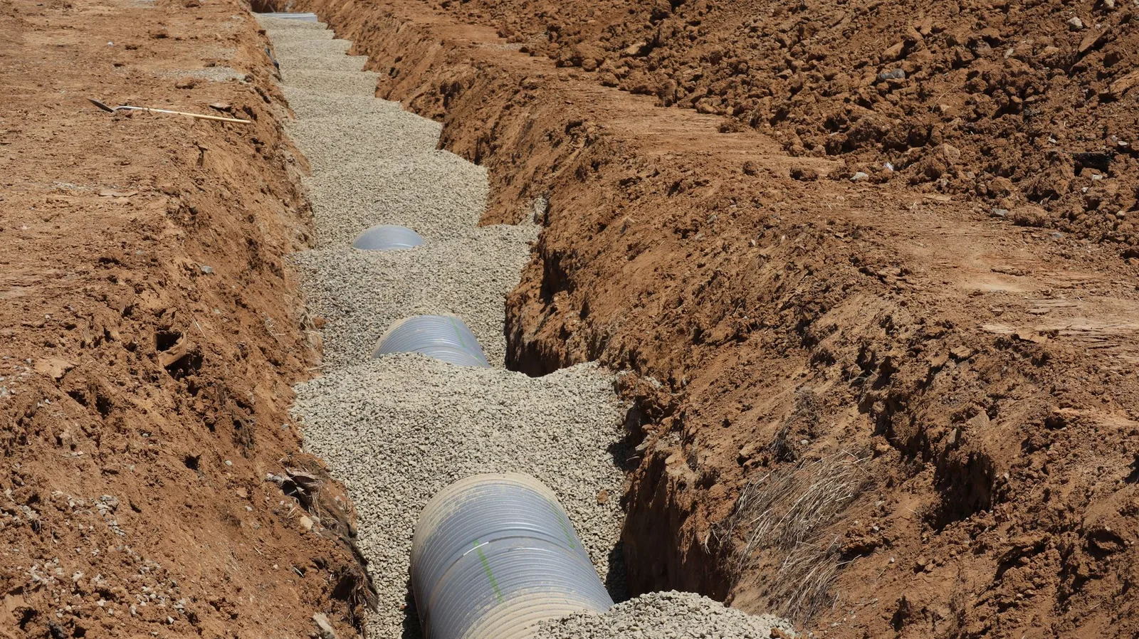 A gravel drain field trench during a septic system installation