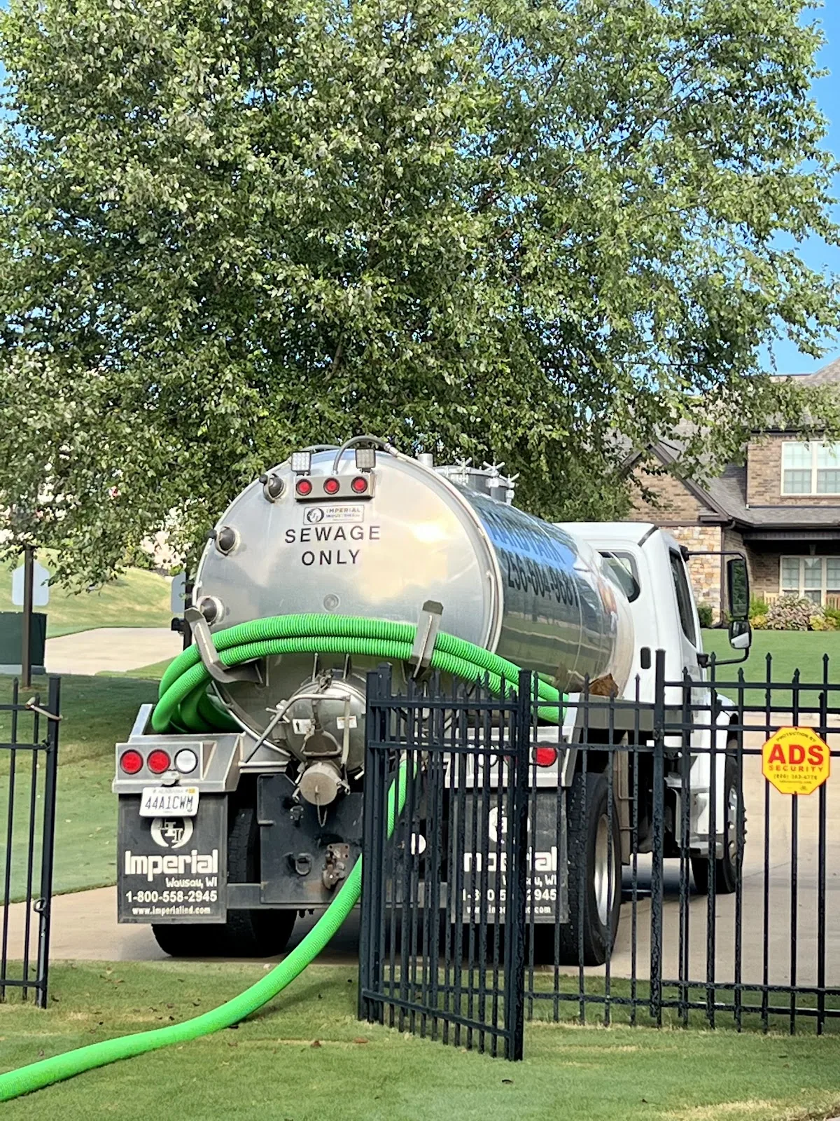 Aardvark stainless vacuum pump truck with the green hose running to a septic tank